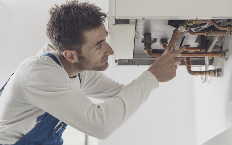 Engineer repairing boiler pipework