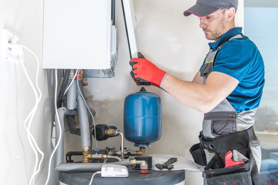 Engineer working on a boiler and expansion vessel